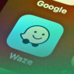 ícone waze no smartphone em fundo amarelo azul e vermelho