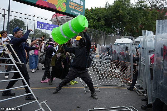 Manifestantes tentam invadir o estádio da Cidade do México, mas são parados por uma linha da polícia de choque