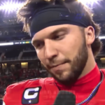 O quarterback do futebol universitário, Brendan Sorsby, vestindo uma camisa vermelha e uma faixa preta na cabeça, fala durante uma entrevista pós-jogo sob as luzes do estádio após uma grande vitória. O juiz libera Brendan Sorsby para retornar à Texas Tech após proibição de jogos de azar da NCAA