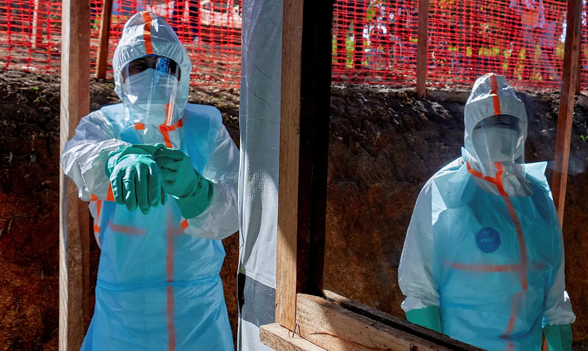 Profissionais de saúde vestem equipamentos de proteção individual (EPI) no Centro Médico Evangélico, uma das instalações na vanguarda da resposta ao surto de Ebola, em Bunia, província de Ituri, República Democrática do Congo, em 31 de maio de 2026. / Crédito: Gradel Muyisa Mumbere/REUTERS