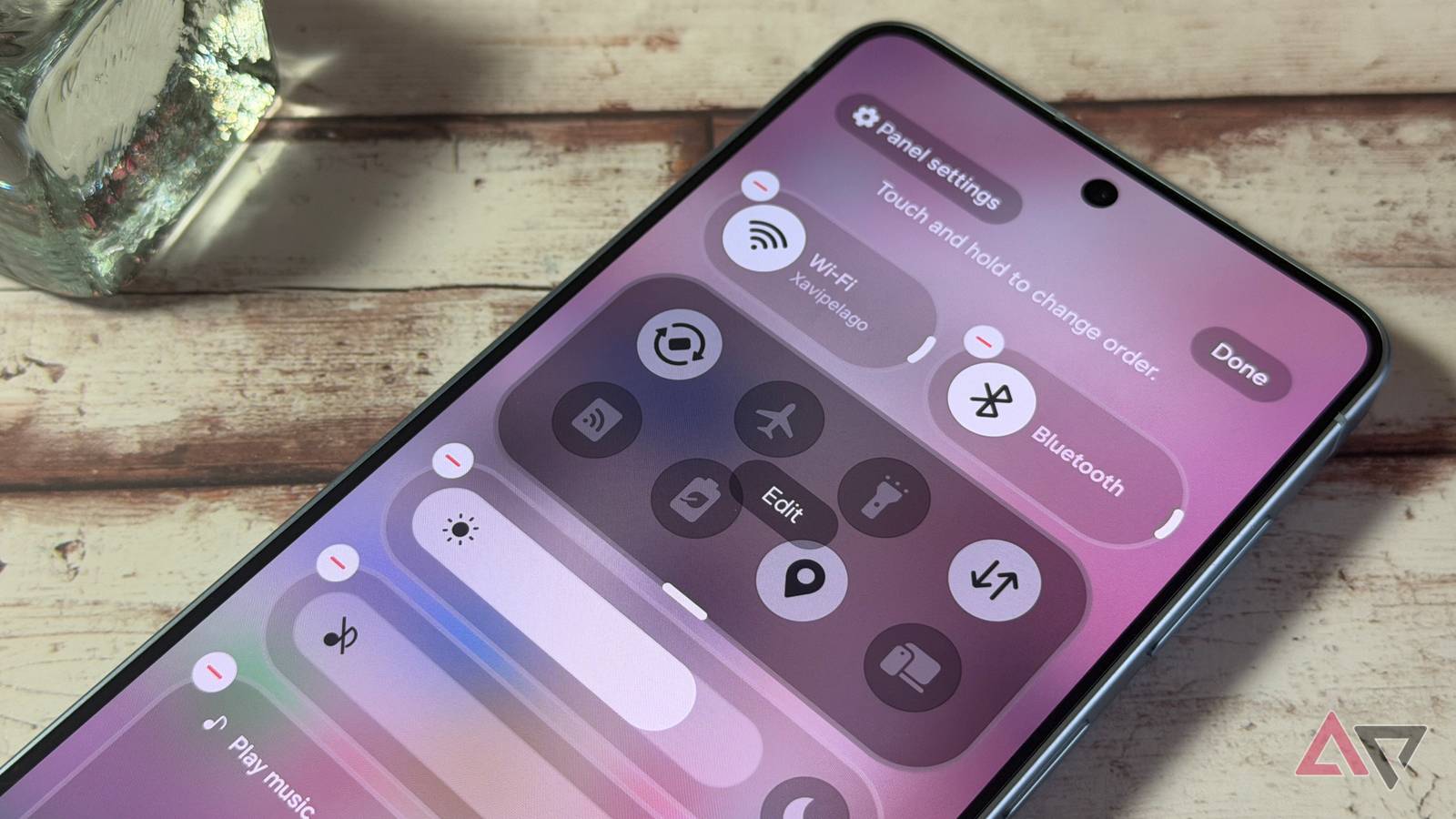 Uma ilustração fotográfica de uma pessoa segurando um Samsung Galaxy Z Flip 6 contra um fundo rosa e amarelo