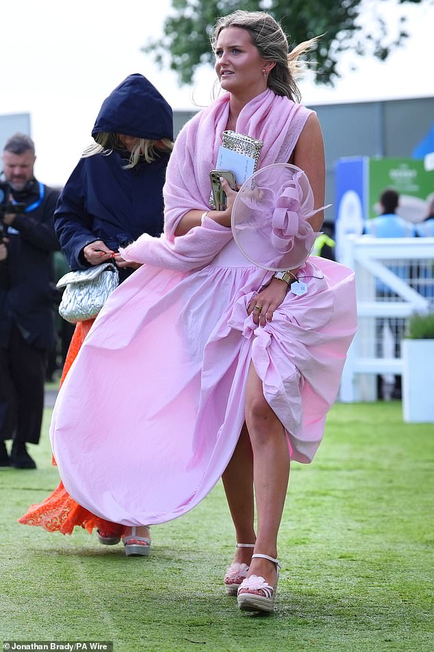 Os participantes da corrida foram vistos se abrigando sob jaquetas, guarda-chuvas e chapéus sob o céu cinzento no sábado, enquanto corriam pelas ruas geralmente sonolentas da vila de Kemble, antes do Epsom Derby.