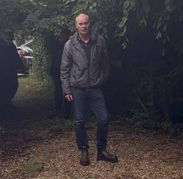 David Moore, 63, dono da Breach House com sua esposa, Dawn, 59, aborda os moradores locais que filmam a cena enquanto os funcionários municipais removem as barreiras da passagem