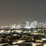 Um raio de luz ilumina o céu durante um ataque de mísseis do Irã contra Israel hoje, visto de Ashkelon