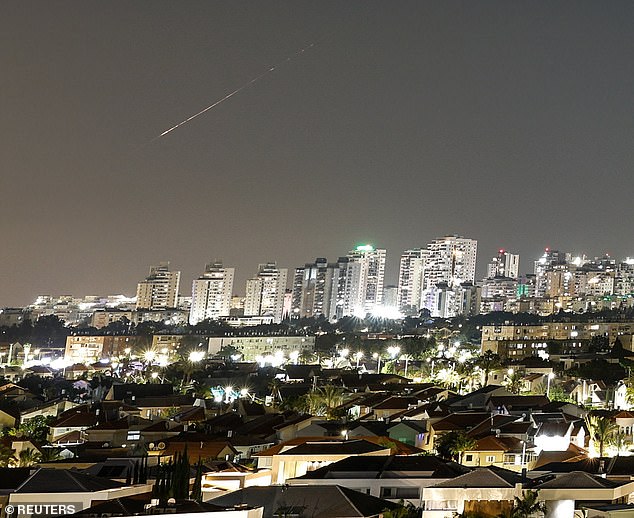 Um raio de luz ilumina o céu durante um ataque de mísseis do Irã contra Israel hoje, visto de Ashkelon