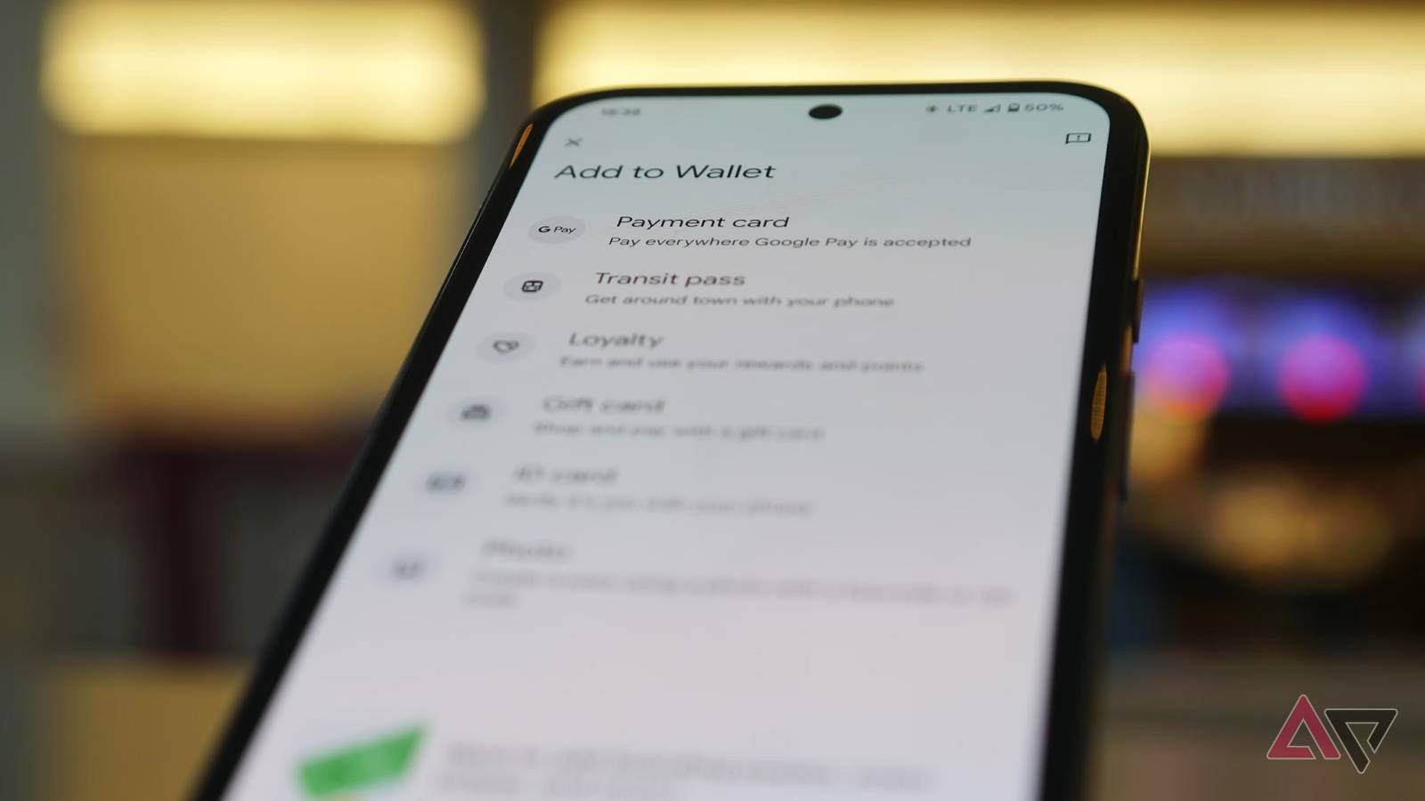 Um telefone Android com passaporte dos EUA na parte superior da tela com fundo desfocado de uma área de espera em um terminal de um aeroporto