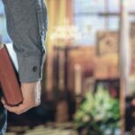 Stock image of a man holding a Bible with a church altar in the background.