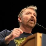 Democratic U.S. Senate candidate Graham Platner speaks at a “Fighting Oligarchy” tour stop held by Senator Bernie Sanders at the Collins Center for the Arts on the University of Maine campus on May 24 in Orono, Maine. (Photo by Joe Raedle/Getty Images)