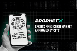 O mercado de previsões esportivas da ProphetX recebe aprovação da CFTC nos Estados Unidos, mostrado em um gráfico promocional apresentando um smartphone exibindo o selo da Commodity Futures Trading Commission e um texto anunciando a aprovação nacional para a bolsa de previsões esportivas regulamentada pelo governo federal.