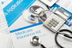 Documentos de inscrição no seguro Medicare com estetoscópio e calculadora, ilustrando investigações de fraude na área de saúde, pedidos de reembolso do Medicare, cobranças médicas e casos de evasão fiscal. Proprietário do laboratório de Burbank preso após fraude do Medicare financiar hábito de jogo