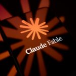 The Claude Fable logo is displayed on the screen of a smartphone placed on a reflective surface onto which the company's icon is projected.