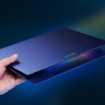 Um laptop prateado exibindo 'Aluminum OS' ao lado de um mascote 3D do Android em um fundo verde.