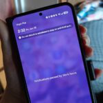 um telefone na mão exibindo uma notificação de um jogo para celular