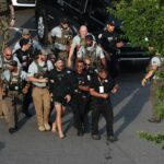MMA fighter Sean Strickland is escorted out of the UFC Freedom 250 Fan Fest on The Ellipse by U.S. Secret Service and other law enforcement ahead of UFC Freedom 250 on the South Lawn of the White House on Sunday, June 14, 2026, in Washington. (Kevin Dietsch/Pool Photo via AP)
