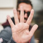 Apple Intelligence oferece uma nova oportunidade para bloquear notificações indesejadas | A foto mostra um homem levantando a mão em um gesto de parada