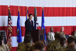 Steil apresenta projeto de lei que restringe as negociações no mercado de previsão do Congresso. O deputado Bryan Steil discursa em um evento militar diante de militares e oficiais, em um pódio em frente a uma grande bandeira americana enquanto discute a política do Congresso e as reformas éticas do governo.