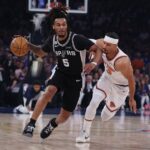 San Antonio Spurs guard Stephon Castle drives past New York Knicks star Josh Hart in NBA Finals game