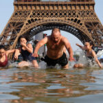 Abdul Saboor/Reuters - FOTO: Um homem mergulha na água do Canal Saint-Martin enquanto as temperaturas aumentam durante uma onda de calor que afeta grande parte do país, em Paris, França, em 22 de junho de 2026.