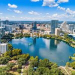 Vista aérea do horizonte do centro de Orlando, Flórida, ao redor do Lago Eola, sob um céu azul brilhante com arranha-céus modernos e parques à beira-mar. Tribunal de apelações da Flórida mantém revogação da licença em meio à revisão dos jogos Seminole