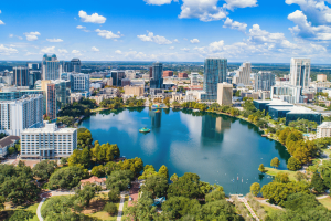 Vista aérea do horizonte do centro de Orlando, Flórida, ao redor do Lago Eola, sob um céu azul brilhante com arranha-céus modernos e parques à beira-mar. Tribunal de apelações da Flórida mantém revogação da licença em meio à revisão dos jogos Seminole