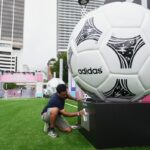Jorge Gonzalez cleans a display featuring giant soccer balls, replicas from former World Cup tournaments, during a media preview of a Fan Festival for the World Cup soccer tournament, Wednesday, June 10, 2026, at Bayfront Park in Miami.