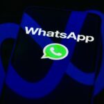 The WhatsApp logo is displayed on a mobile phone screen in this photo illustration.