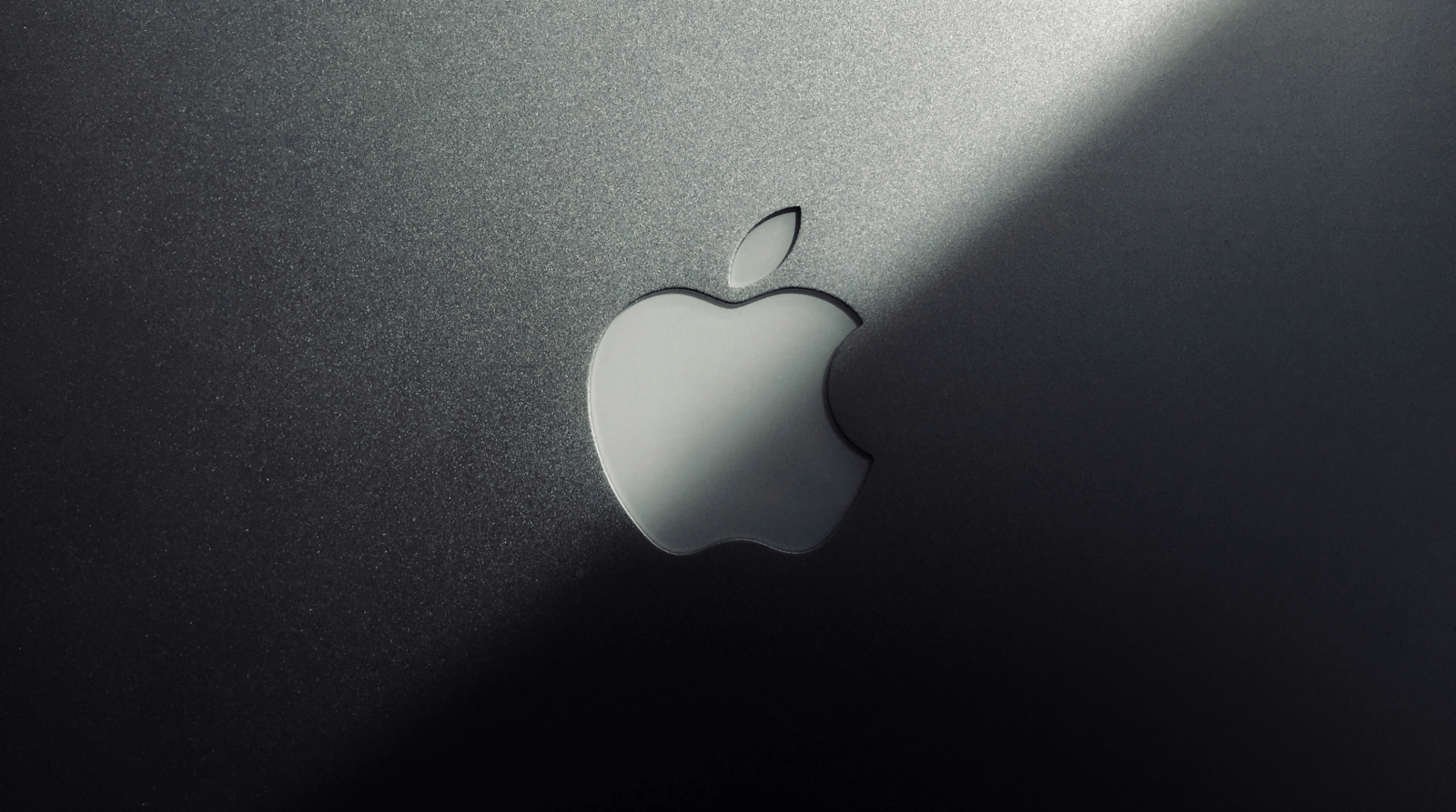 parte superior da tampa de um MacBook mostrando o logotipo da Apple