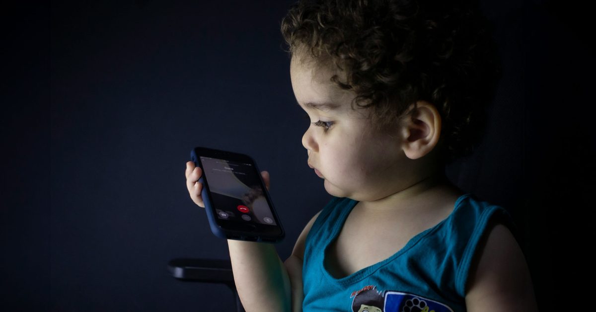 A Apple deve continuar a verificar a idade dos usuários no Texas, diz decisão de uma frase | A foto mostra uma criança muito pequena fazendo uma ligação em um iPhone