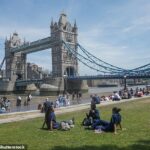 As pessoas aproveitam o sol próximo à Tower Bridge, em Londres, hoje, enquanto o calor continua