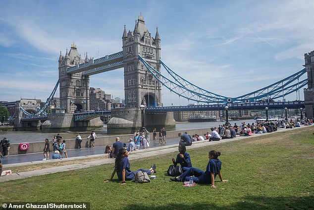 As pessoas aproveitam o sol próximo à Tower Bridge, em Londres, hoje, enquanto o calor continua
