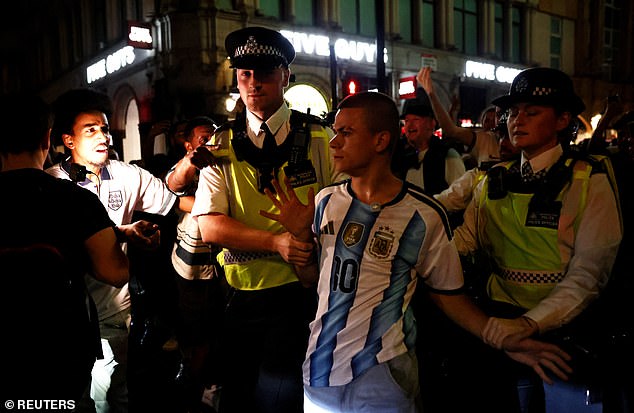 Polícia em Londres escolta um torcedor argentino para longe dos torcedores ingleses após o apito final