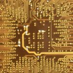 Apple anuncia contrato de chip Broadcom de 30 bilhões como parte da promessa de investimento de 600 bilhões nos EUA | Foto aproximada de um chip de silício dourado