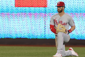 Bryce Harper, do Philadelphia Phillies, se ajoelha em campo antes de um jogo da MLB em meio à controvérsia da promoção de jogos de azar FanDuel Cameo.