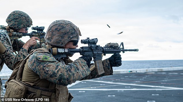 Fuzileiros navais americanos conduzem uma evolução de fogo real na cabine de comando do navio de transporte anfíbio da classe San Antonio, USS New Orleans, em 11 de fevereiro.