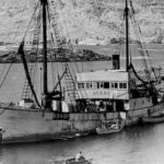 Homem parado em um barco, foto em preto e branco