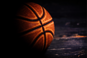 Close de uma bola de basquete em uma quadra de madeira ilustrando a investigação de apostas da NBA, jogos de azar, manipulação de resultados e investigação federal de corrupção. Doze réus preparam confissões de culpa em caso de fraude de pôquer fraudulento relacionado à NBA