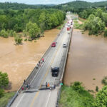 Heartland News - FOTO: Pessoas ficam em uma ponte acima das enchentes do Rio Black em Lesterville, Missouri, 10 de julho de 2026.