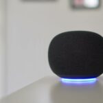 Três alto-falantes do Google Home exibidos abaixo do texto 'Coming Spring 2026' em um fundo verde claro.