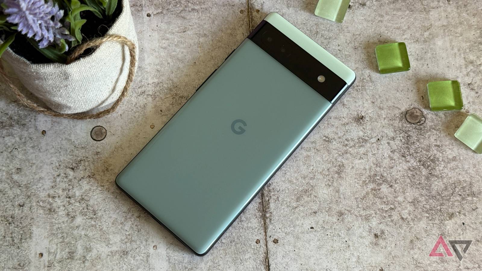 Google Pixel 6a cercado por contas verdes