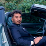 Laurence Escalante, fundador da Virtual Gaming Worlds (VGW), sentado em um carro esportivo conversível.