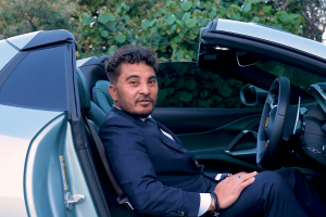 Laurence Escalante, fundador da Virtual Gaming Worlds (VGW), sentado em um carro esportivo conversível.