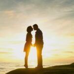 O iPhone contribuiu para ‘um colapso na fertilidade dos EUA’, afirma estudo científico | A foto mostra um casal se beijando em uma costa, em silhueta contra um pôr do sol