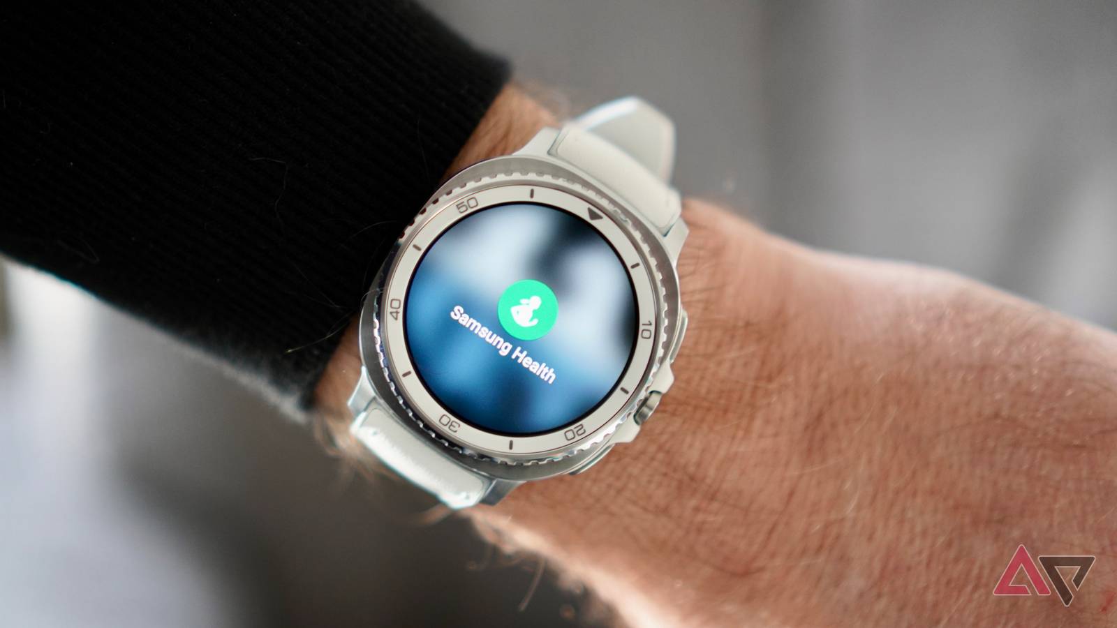 Samsung Galaxy Watch com fios saindo do braço de uma pessoa com roupa de hospital