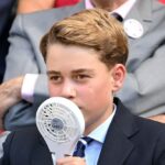 O príncipe George parecia ter sido afetado pelo calor sufocante de 29ºC enquanto se refrescava com um ventilador portátil