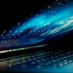 Cuidado com relatórios falsos de falhas do Mac | A imagem mostra um MacBook parcialmente aberto com gráficos abstratos em azul