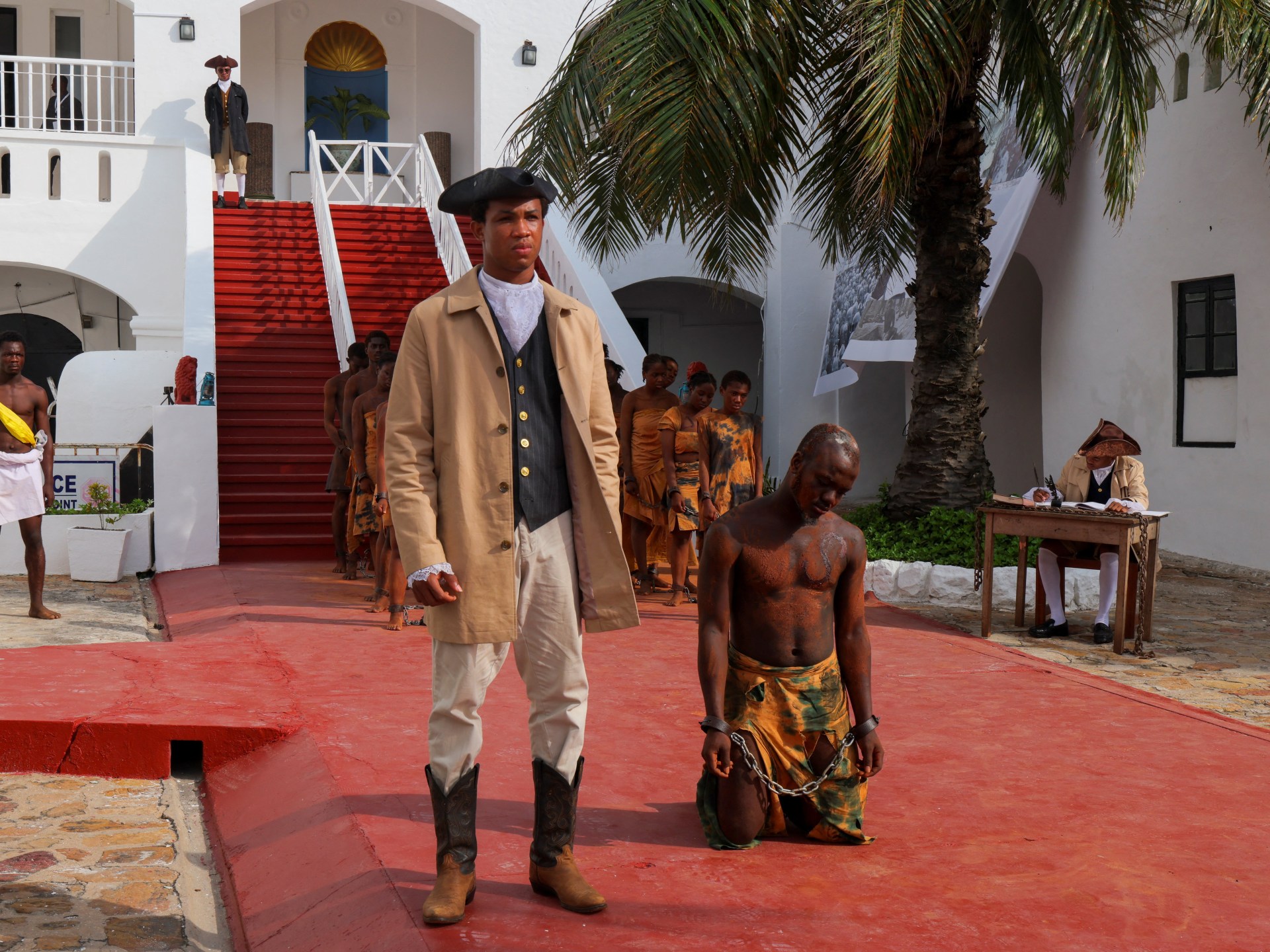 Artistas apresentam uma reconstituição do comércio transatlântico de escravos no Castelo de Christiansborg, um antigo posto de escravos, durante uma conferência consultiva de alto nível sobre os próximos passos para a histórica resolução das Nações Unidas sobre o tráfico de africanos escravizados, em Accra, Gana (Francis Kokoroko/Reuters)