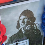 Uma foto emoldurada em close do piloto tcheco Alois Vasatko colocou ao lado um memorial feito em sua memória. Nele, ele usa uniforme e capacete voador. Há coroas de papoula e homenagens ao lado.