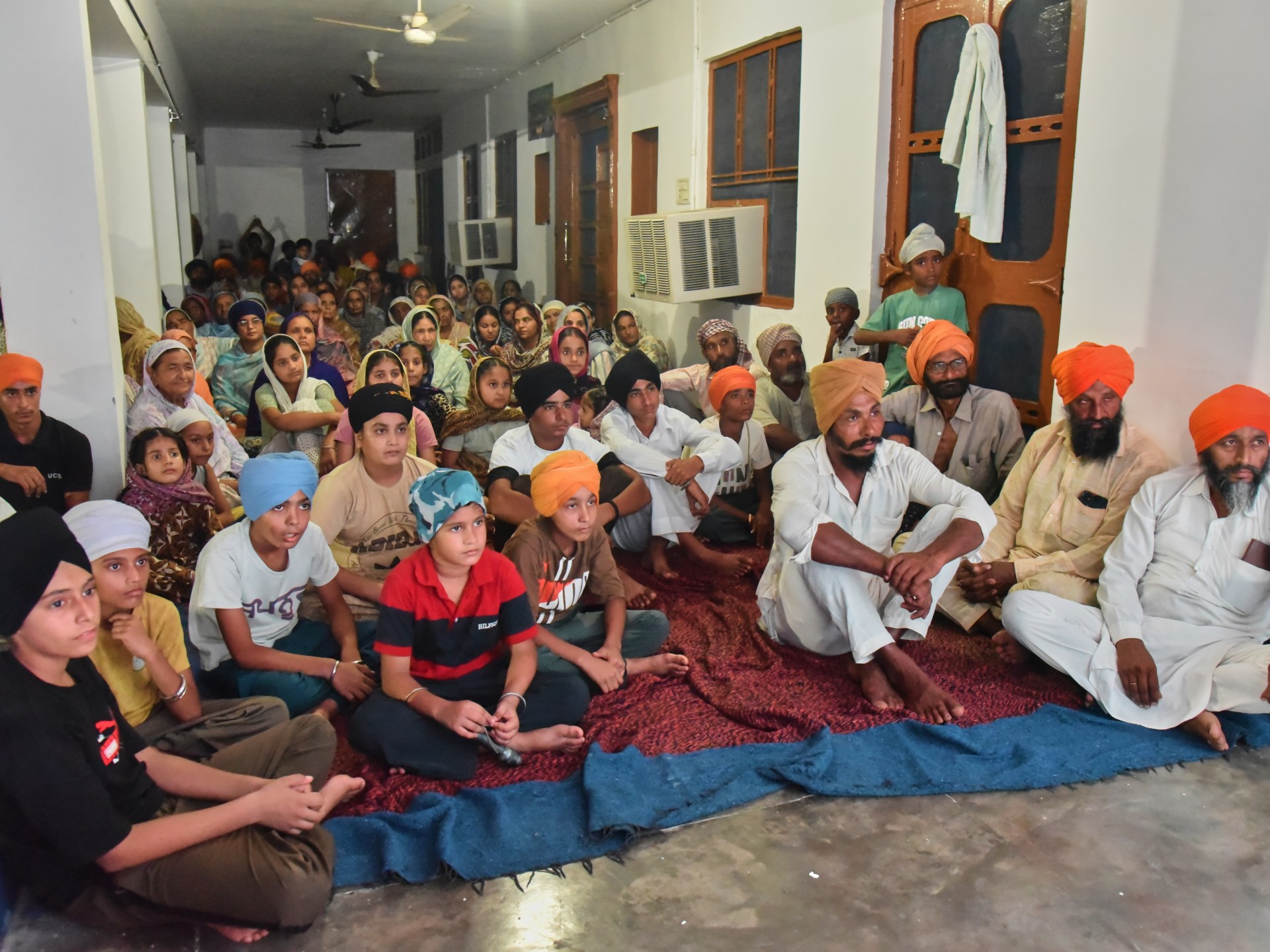 Aldeões assistem a uma exibição especial de Satluj em um templo Sikh na vila de Tatley, no distrito de Gurdaspur, Punjab, Índia, 8 de julho de 2026