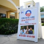 An Obamacare sign is displayed outside an insurance agency on November 12, 2025 in Miami, Florida.