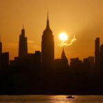 Gary Hershorn/ABC News - FOTO: O sol nasce atrás do horizonte do centro de Manhattan, do Chrysler Building e do Empire State Building em um dia com alerta de calor extremo na cidade de Nova York, 2 de julho de 2026.